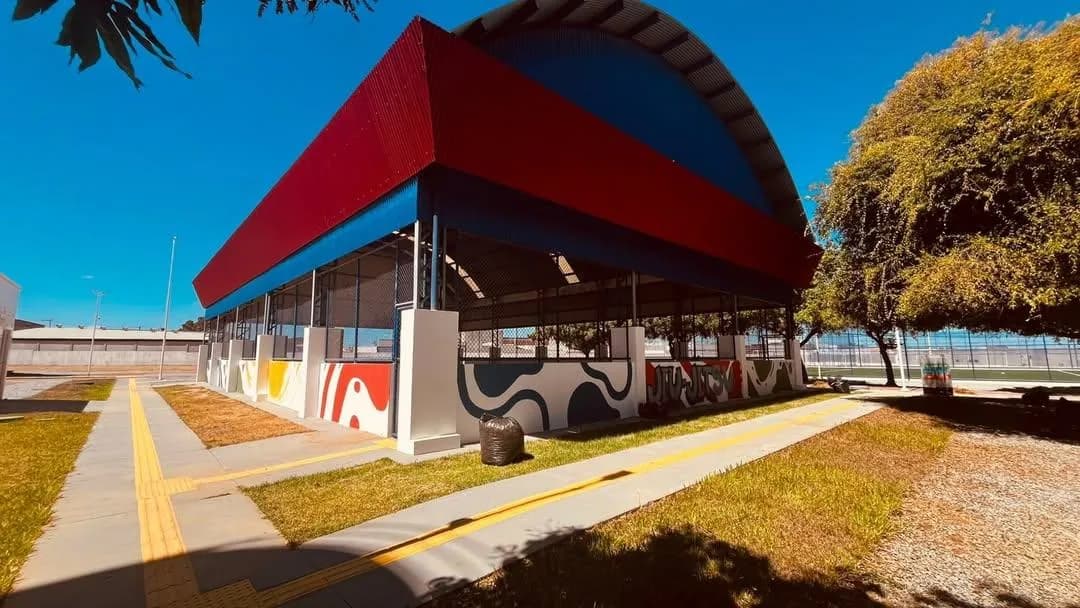 Arena multiuso entregue pela CBS, com fachada em vermelho, branco e azul-marinho e pista de atletismo em primeiro plano