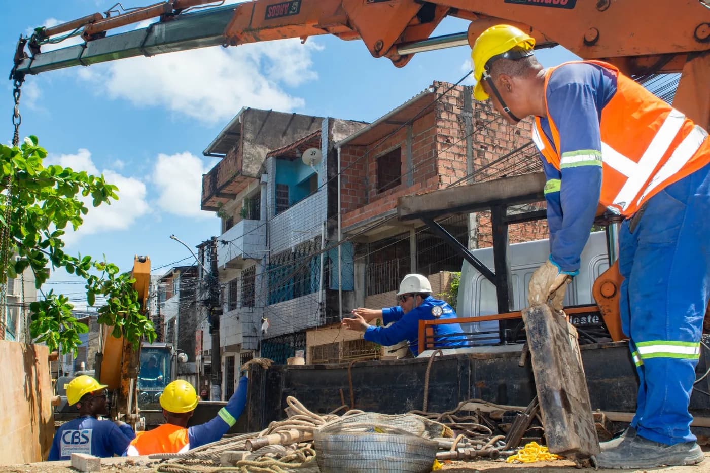 Colaborador da CBS, de capacete e camisa com a marca, operando estação total em levantamento topográfico de campo